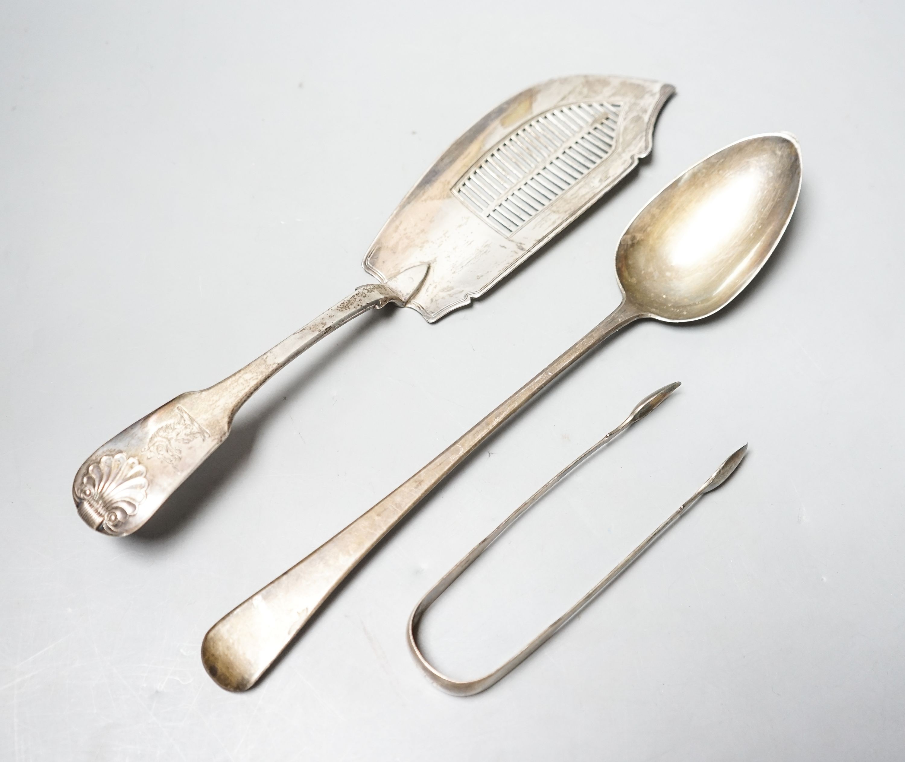 A late George III silver fiddle and shell pattern fish slice, London, 1819, a pair of silver sugar tongs and a George IV silver basting spoon, 9.5oz.